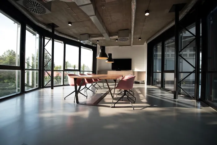 Modern glass-walled office meeting room with polished floors