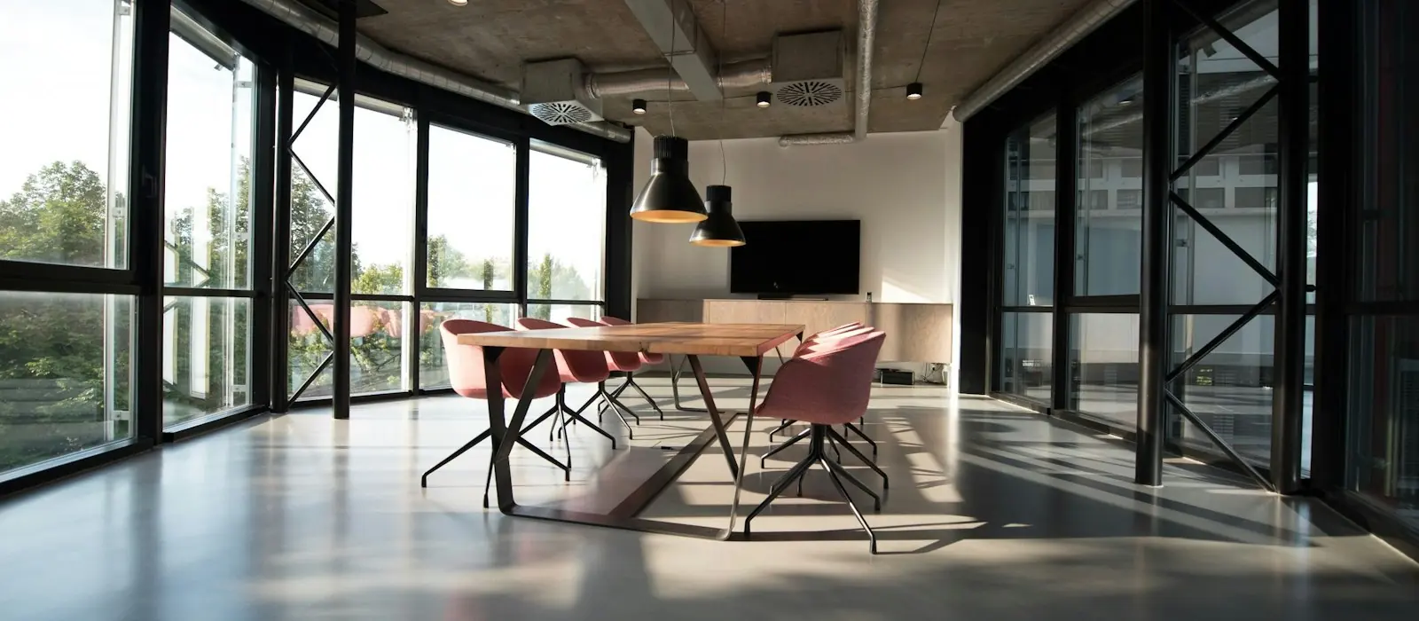 Modern glass-walled office meeting room with polished floors